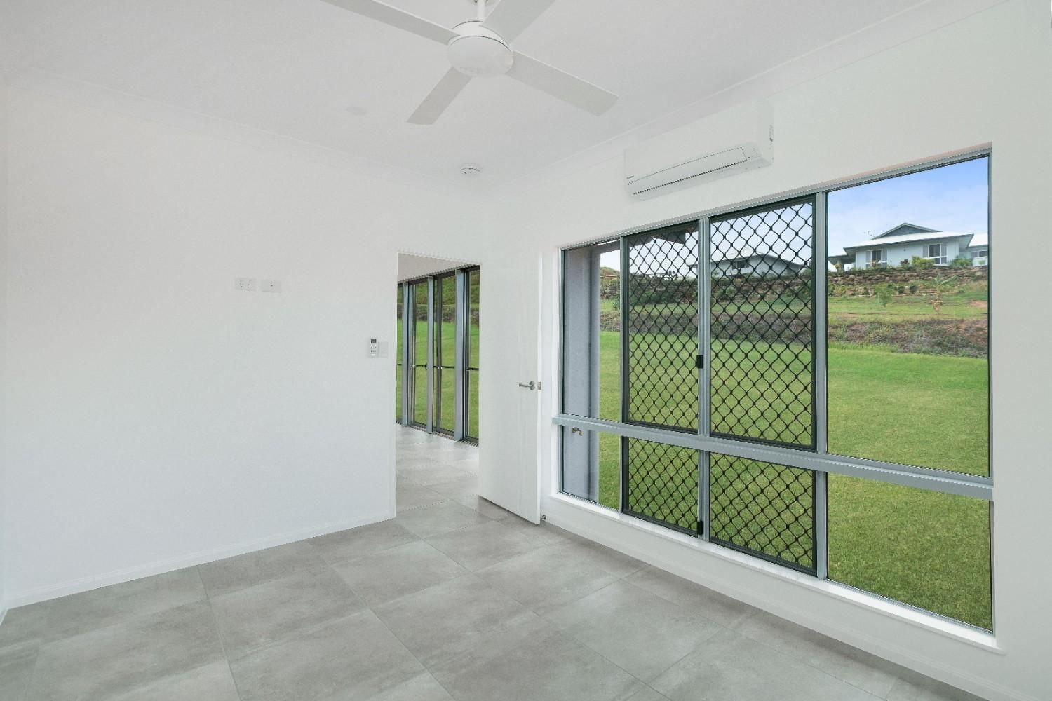 An Empty Room With a Lot of Windows and a Ceiling Fan — Ashlee Jones Homes in Gordonvale, QLD