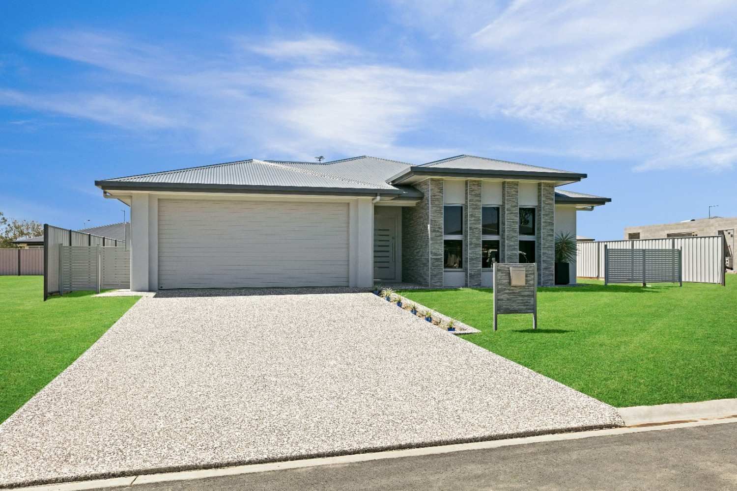 A White House With a Gravel Driveway in Front of It — Ashlee Jones Homes in Gordonvale, QLD