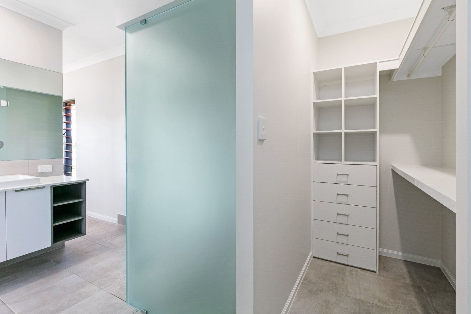 A Bathroom With a Walk in Closet and a Glass Door — Ashlee Jones Homes in Gordonvale, QLD