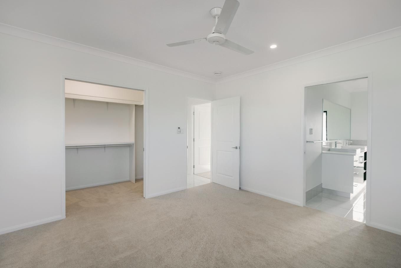 An Empty Room With a Ceiling Fan and a Bathroom — Ashlee Jones Homes in Gordonvale, QLD