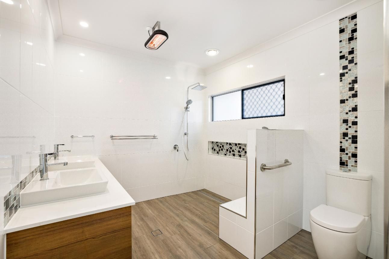 A Bathroom With a Toilet, Sink and Shower — Ashlee Jones Homes in Gordonvale, QLD