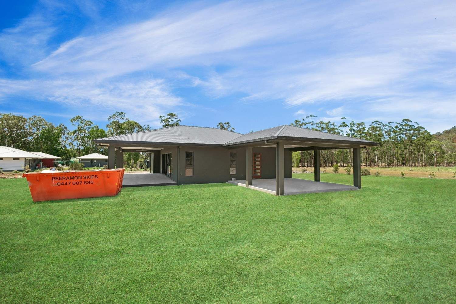 A Large House is Sitting on Top of a Lush Green Field — Ashlee Jones Homes in Gordonvale, QLD