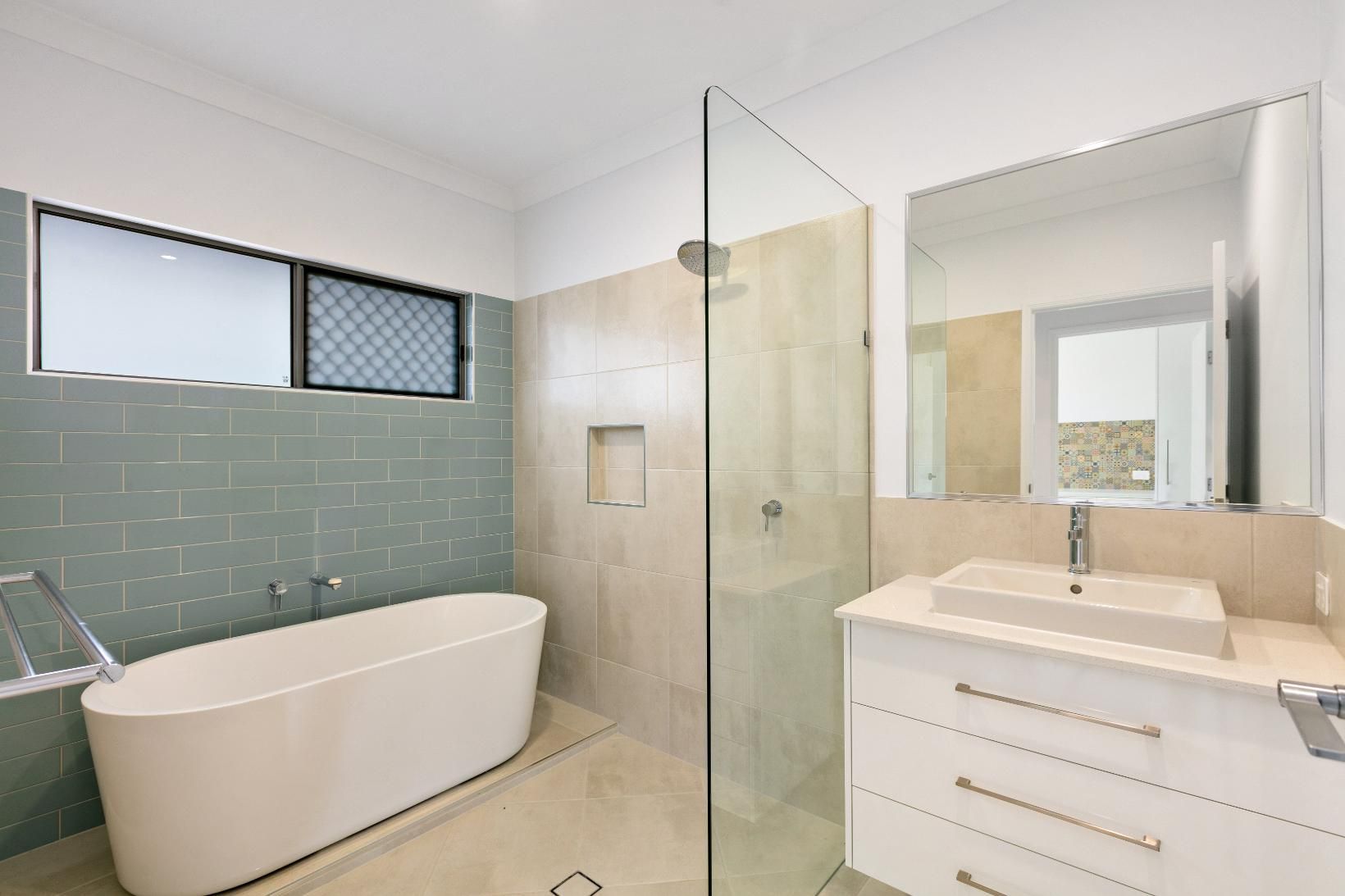 A Bathroom With a Bathtub, Sink, and Walk in Shower — Ashlee Jones Homes in Gordonvale, QLD