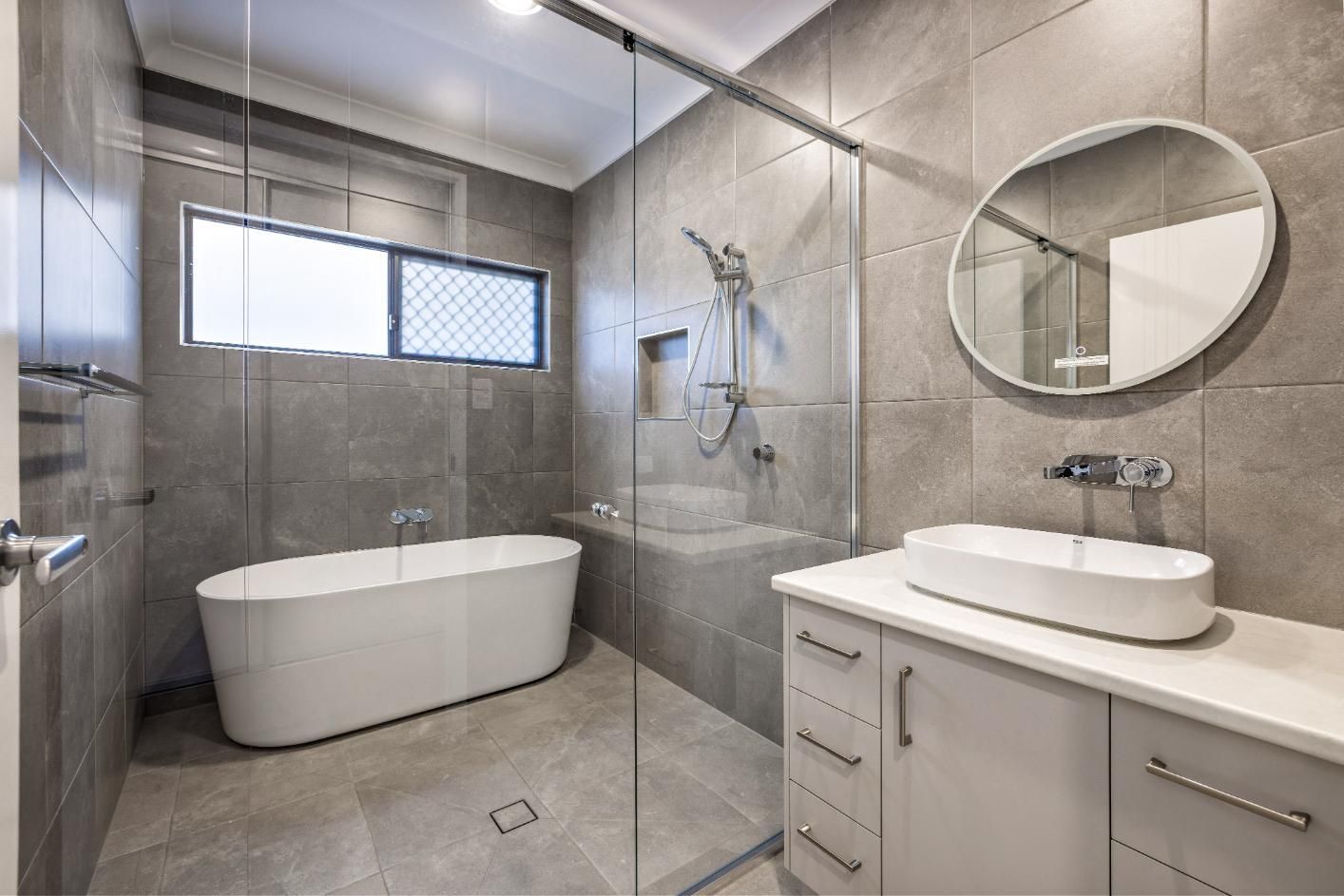 A Bathroom With a Bathtub, Sink, Shower and Mirror — Ashlee Jones Homes in Gordonvale, QLD