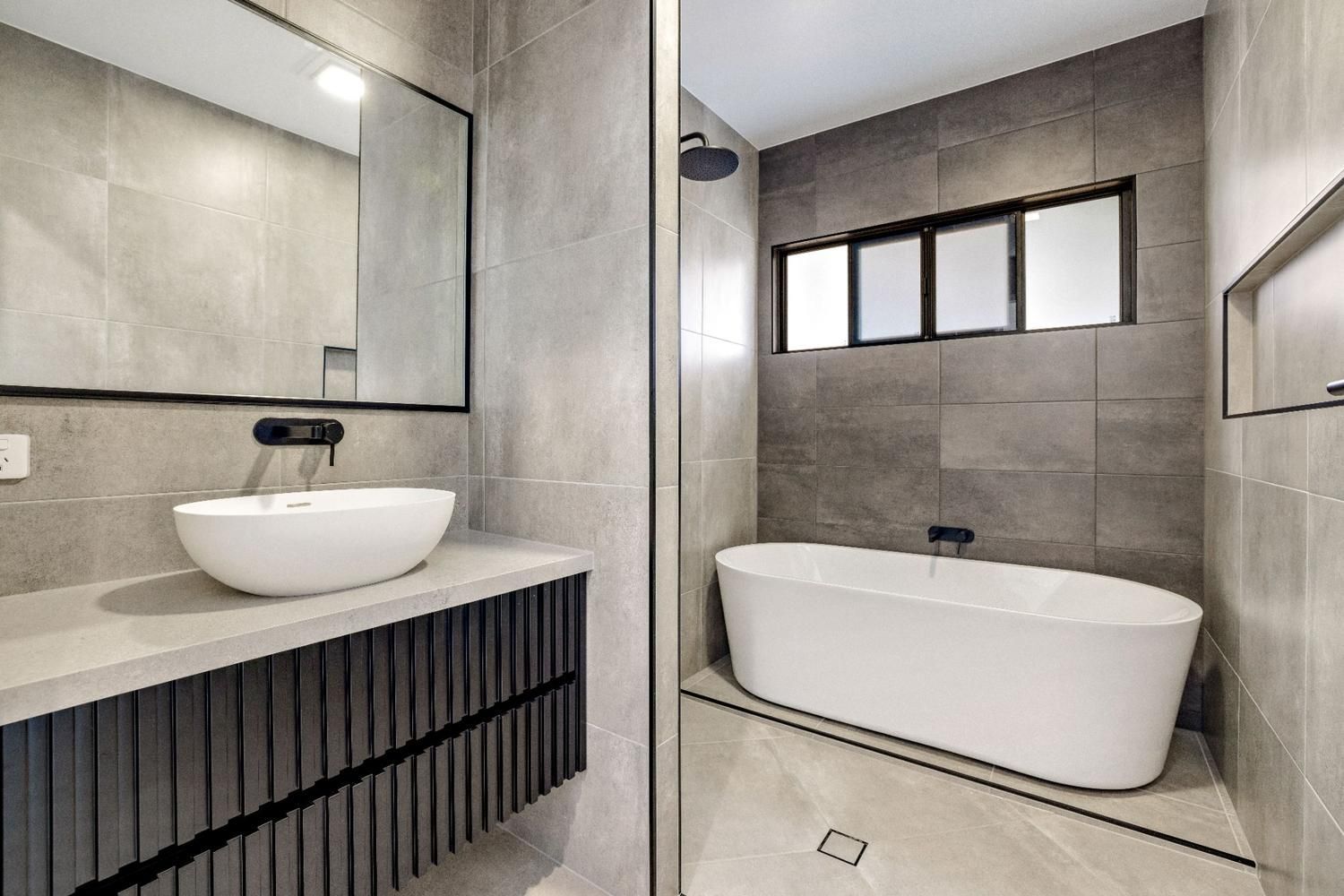 A Bathroom With a Tub, Sink, Mirror and Shower — Ashlee Jones Homes in Gordonvale, QLD