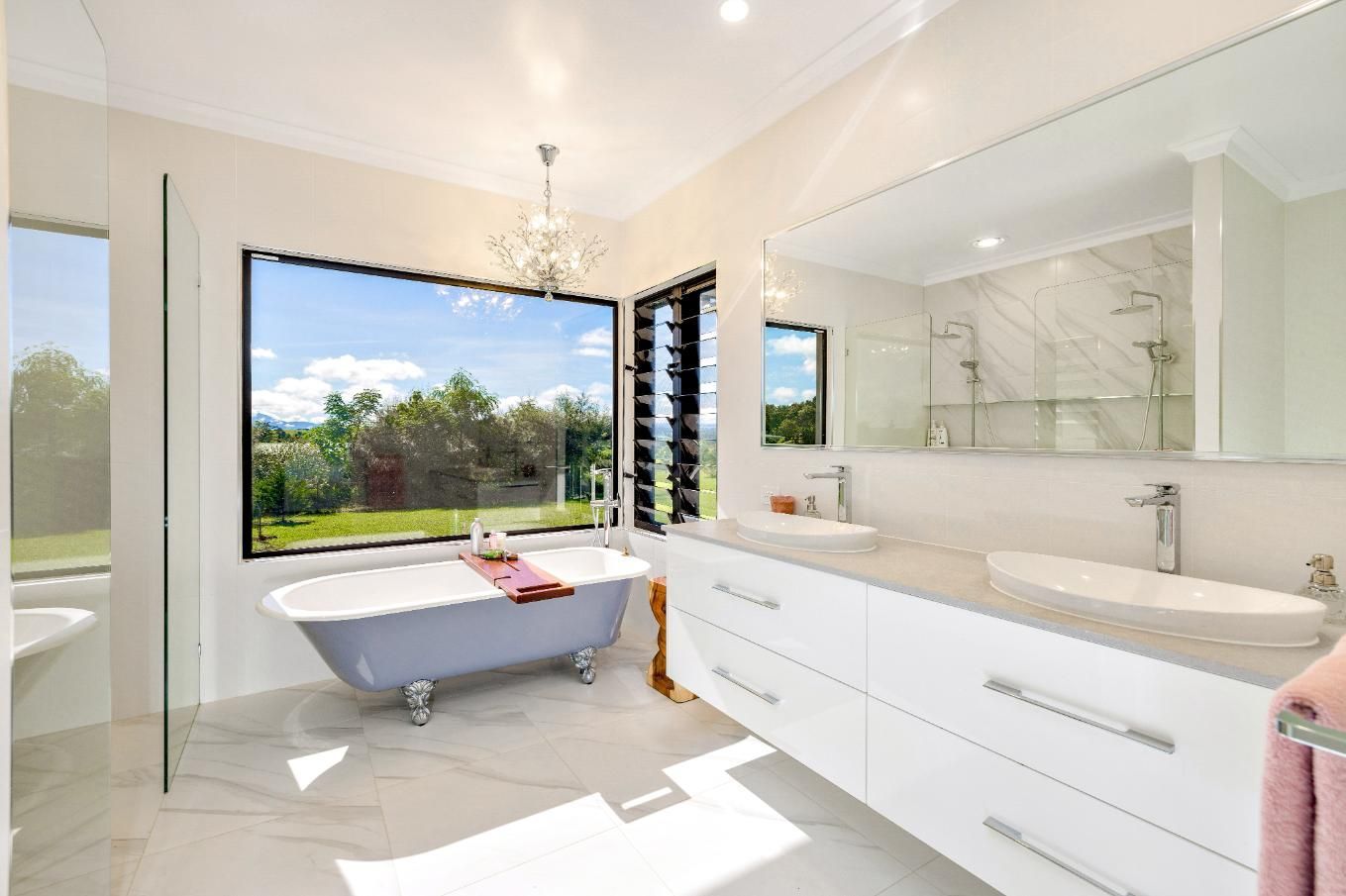 A Bathroom With a Bathtub, Sinks, Mirrors and a Large Window — Ashlee Jones Homes in Gordonvale, QLD