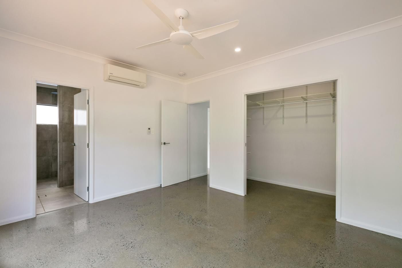 A Large Empty Room With a Ceiling Fan and a Walk in Closet — Ashlee Jones Homes in Gordonvale, QLD