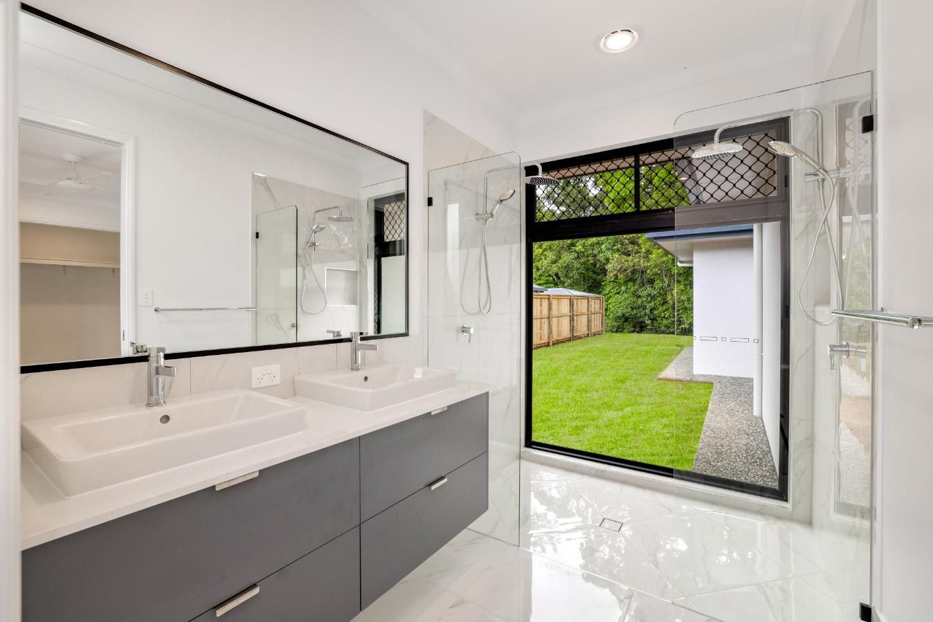 A Bathroom With Two Sinks, a Shower and a Large Window — Ashlee Jones Homes in Gordonvale, QLD