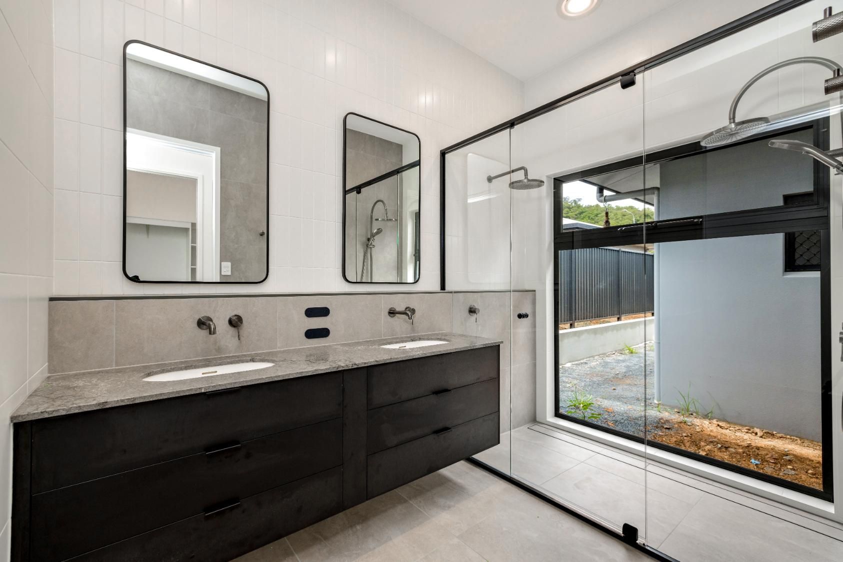 A Bathroom with Two Sinks, Two Mirrors and A Large Window — Ashlee Jones Homes in Gordonvale, QLD