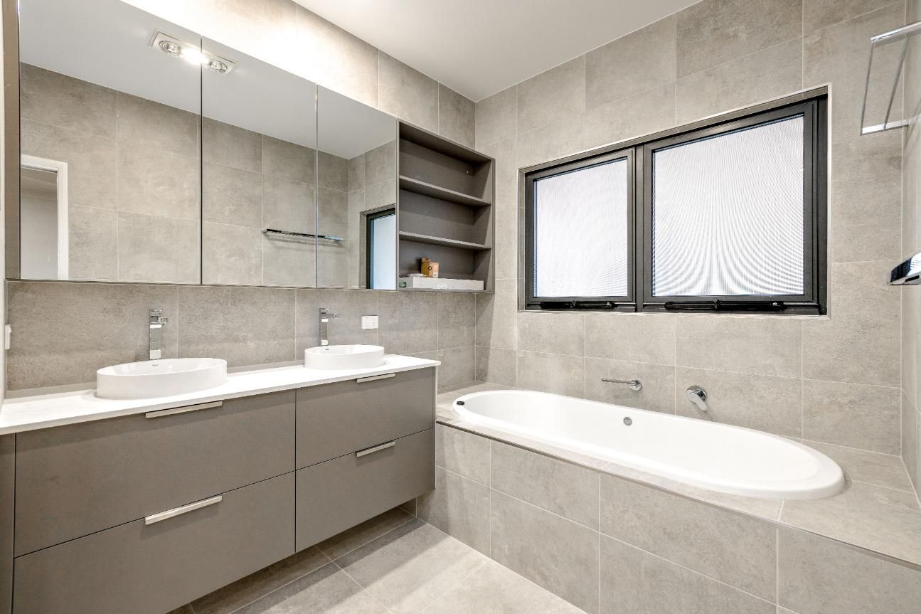 A Bathroom With Two Sinks and a Bathtub — Ashlee Jones Homes in Gordonvale, QLD