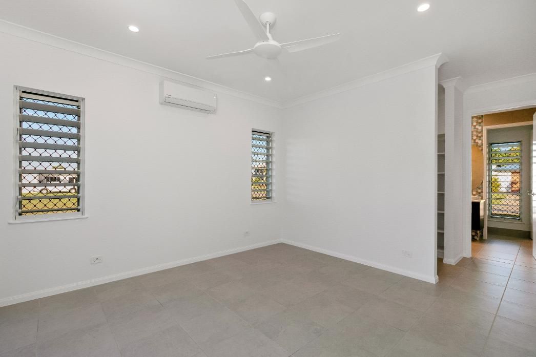 An Empty Room With a Ceiling Fan and Two Windows — Ashlee Jones Homes in Gordonvale, QLD