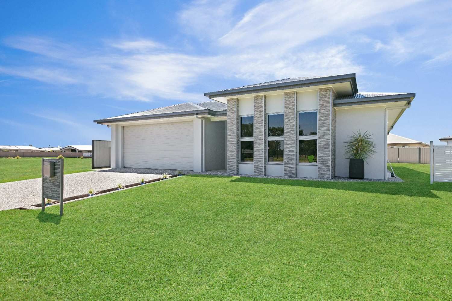 A White House With a Large Lawn in Front of It — Ashlee Jones Homes in Gordonvale, QLD