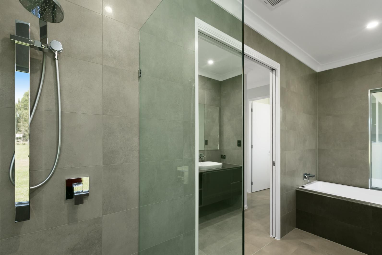 A Bathroom With a Walk in Shower and a Bathtub — Ashlee Jones Homes in Gordonvale, QLD