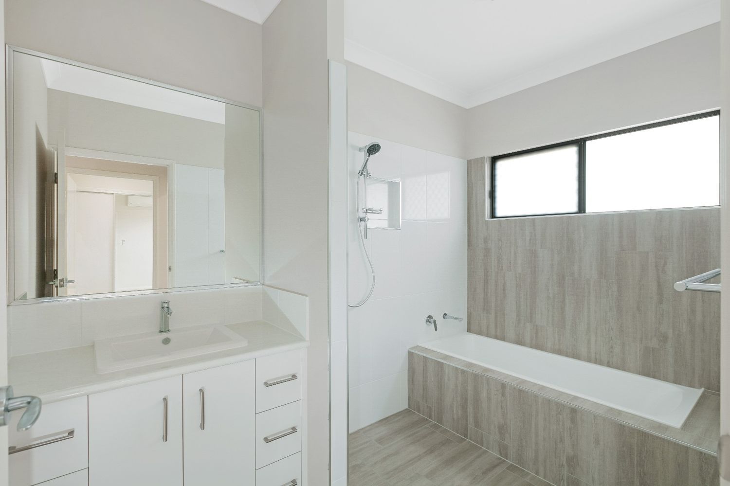 A Bathroom With a Sink, Tub, Shower and Mirror — Ashlee Jones Homes in Gordonvale, QLD