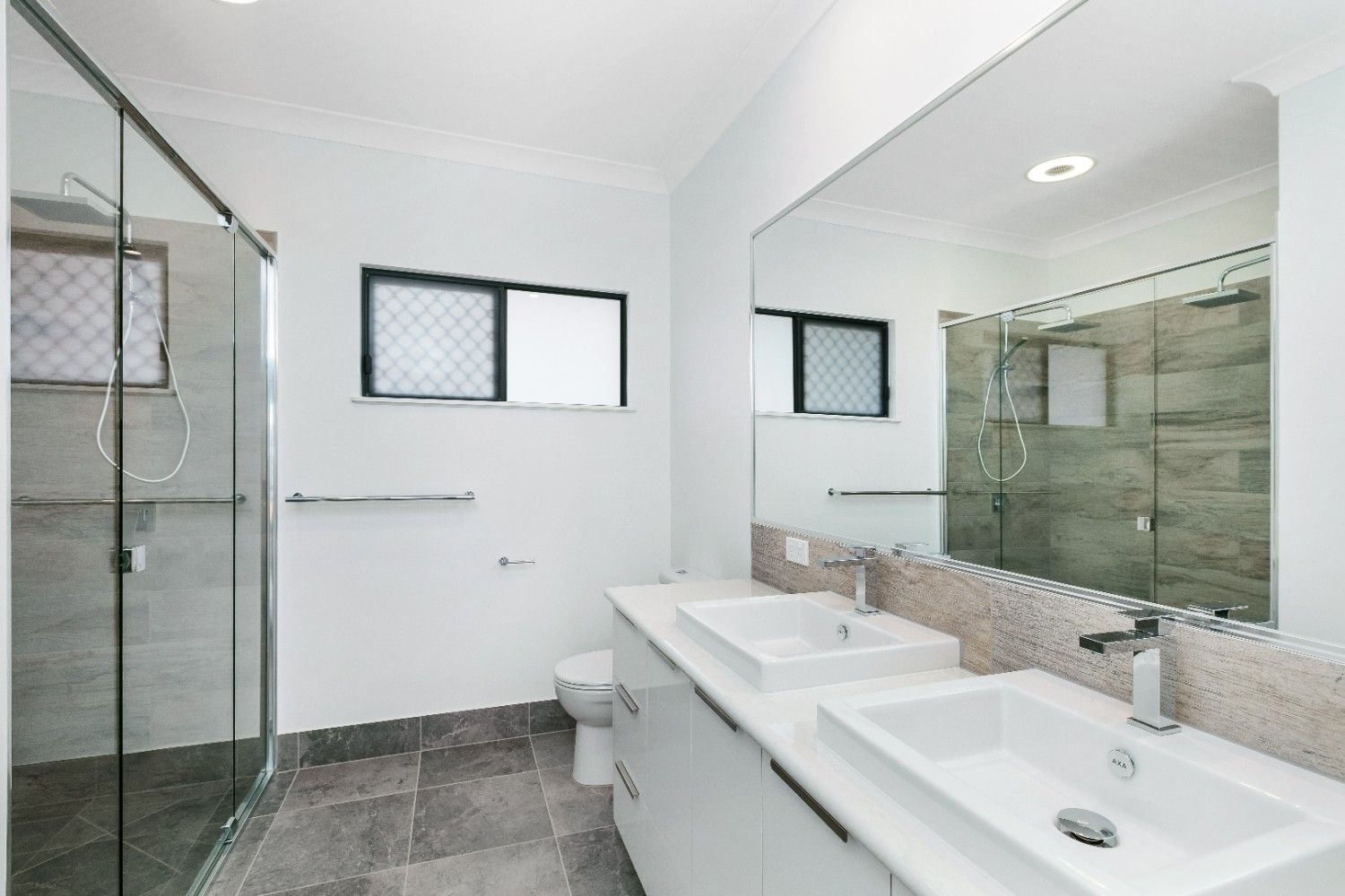 A Bathroom With Two Sinks, a Toilet and a Shower — Ashlee Jones Homes in Gordonvale, QLD