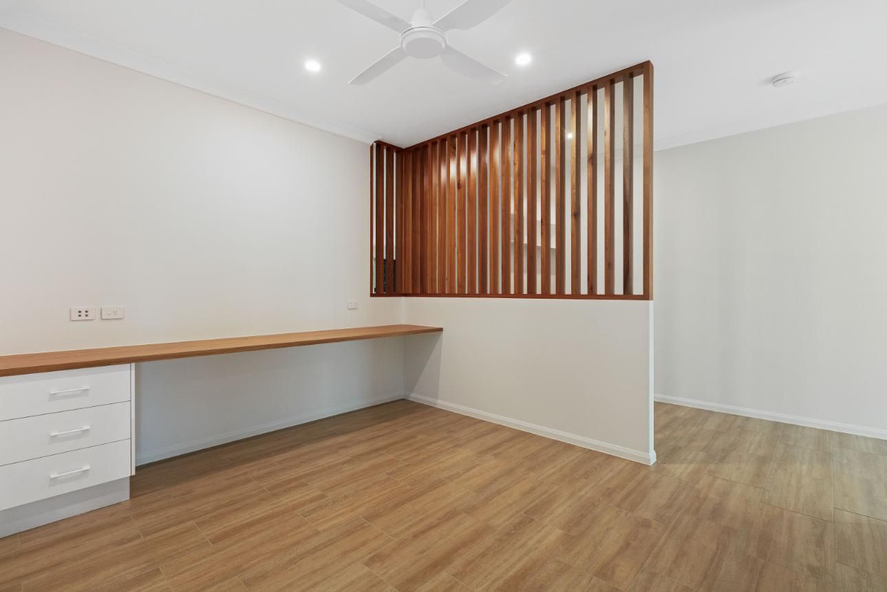 An Empty Room With a Wooden Divider and a Wooden Desk — Ashlee Jones Homes in Gordonvale, QLD