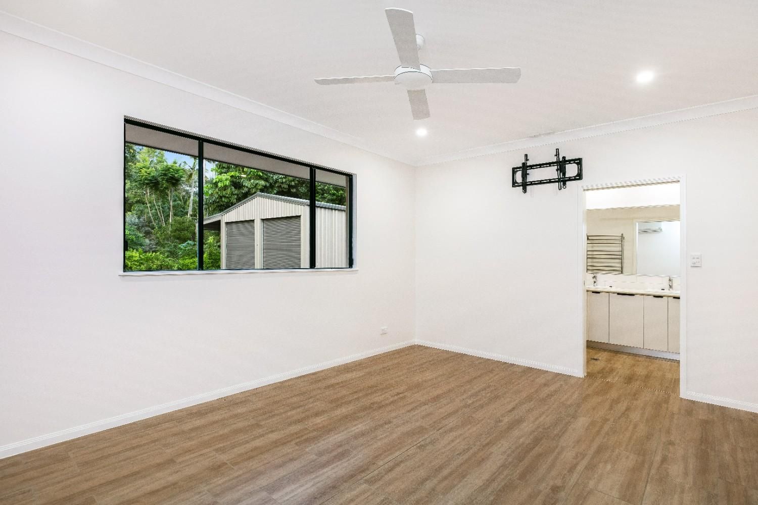 An Empty Living Room With Hardwood Floors — Ashlee Jones Homes in Gordonvale, QLD
