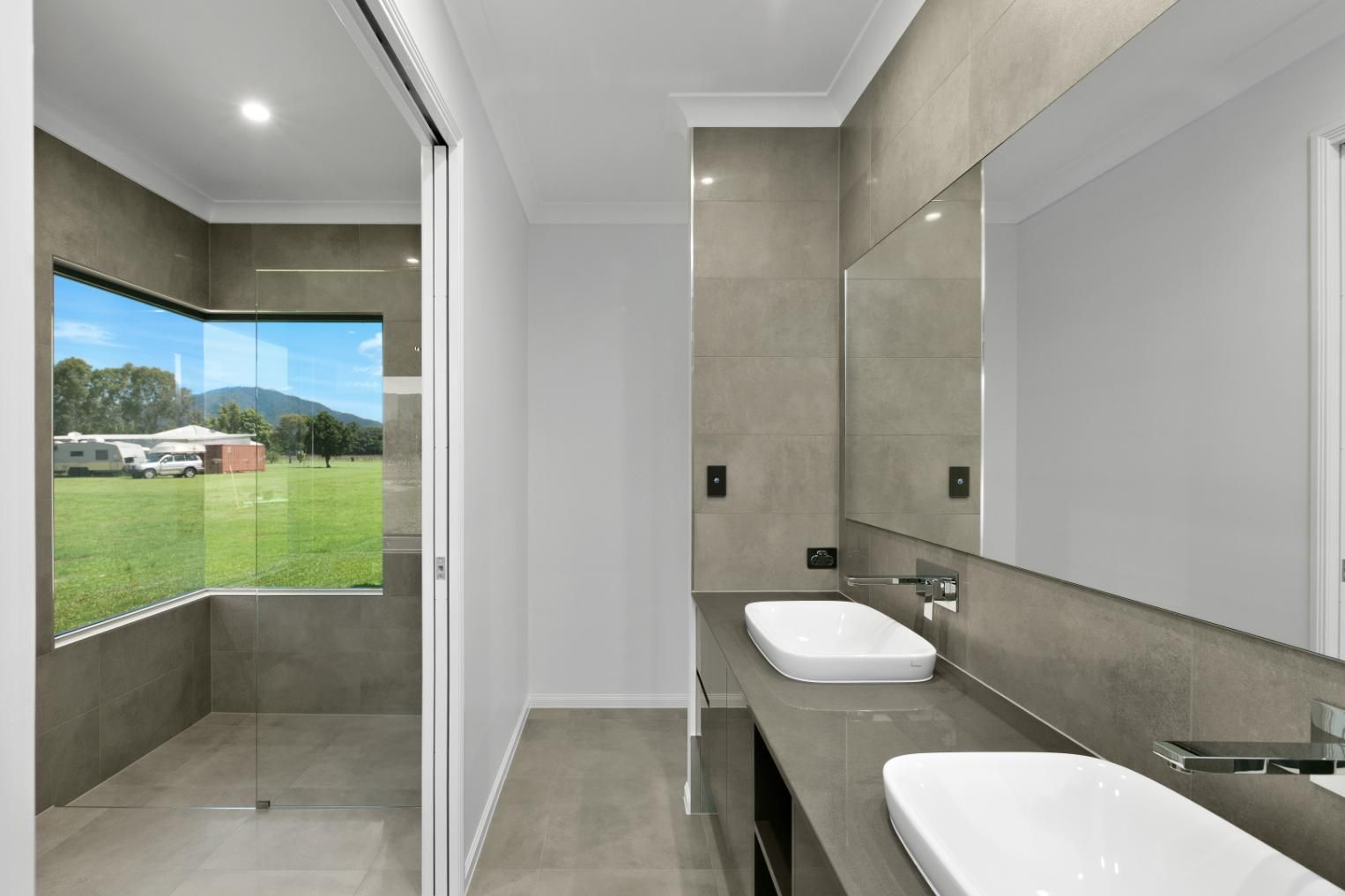 A Bathroom With Two Sinks and a Large Mirror — Ashlee Jones Homes in Gordonvale, QLD