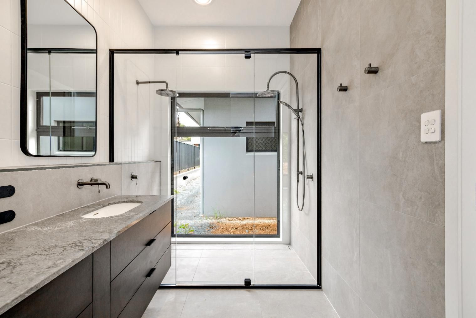 A Bathroom with A Sink, Mirror and Shower — Ashlee Jones Homes in Gordonvale, QLD