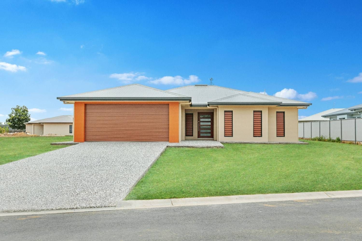 The Front of a House With a Large Garage Door — Ashlee Jones Homes in Gordonvale, QLD