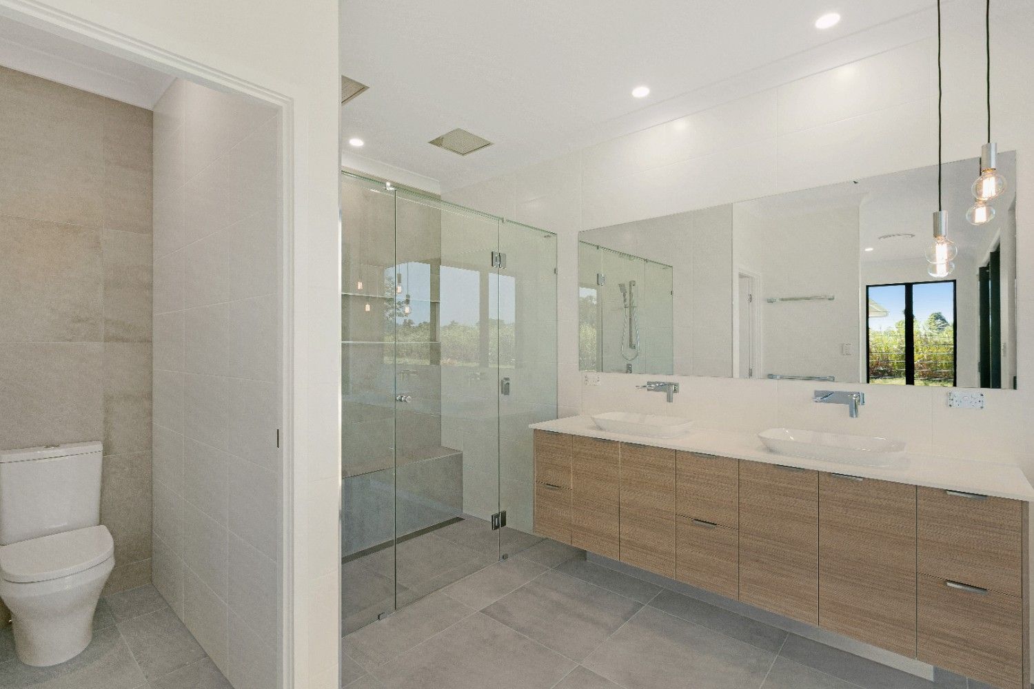 A Bathroom With Two Sinks, a Toilet and a Walk in Shower — Ashlee Jones Homes in Gordonvale, QLD