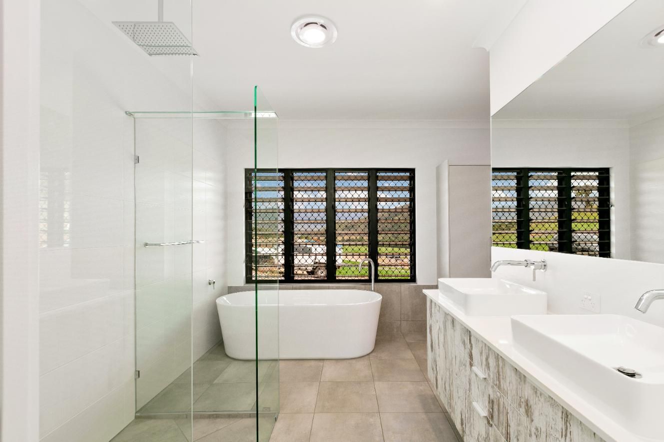 A Bathroom With a Bathtub, Sinks, and a Walk in Shower — Ashlee Jones Homes in Gordonvale, QLD