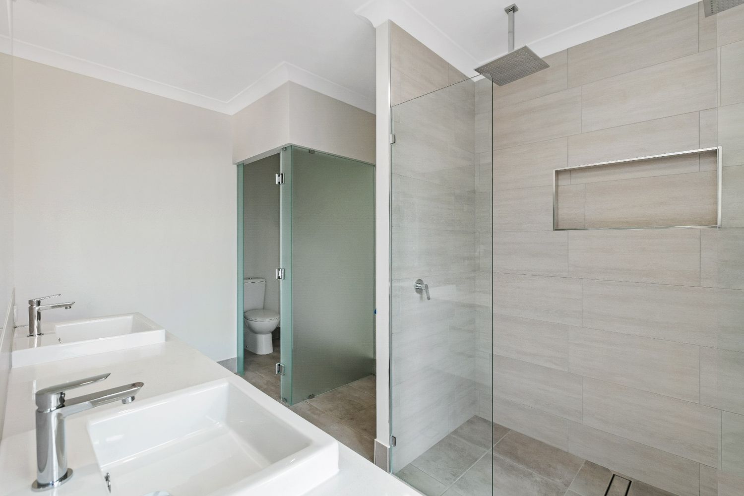 A Bathroom With Two Sinks and a Walk in Shower — Ashlee Jones Homes in Gordonvale, QLD