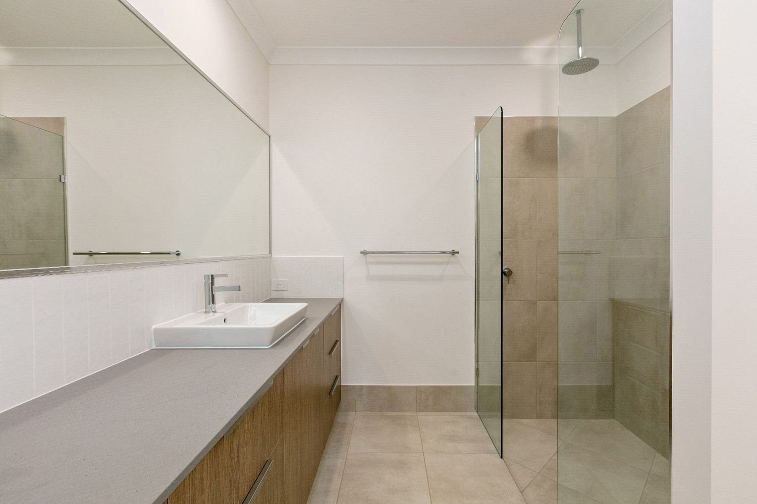 A Bathroom With a Sink, Mirror and Walk in Shower — Ashlee Jones Homes in Gordonvale, QLD