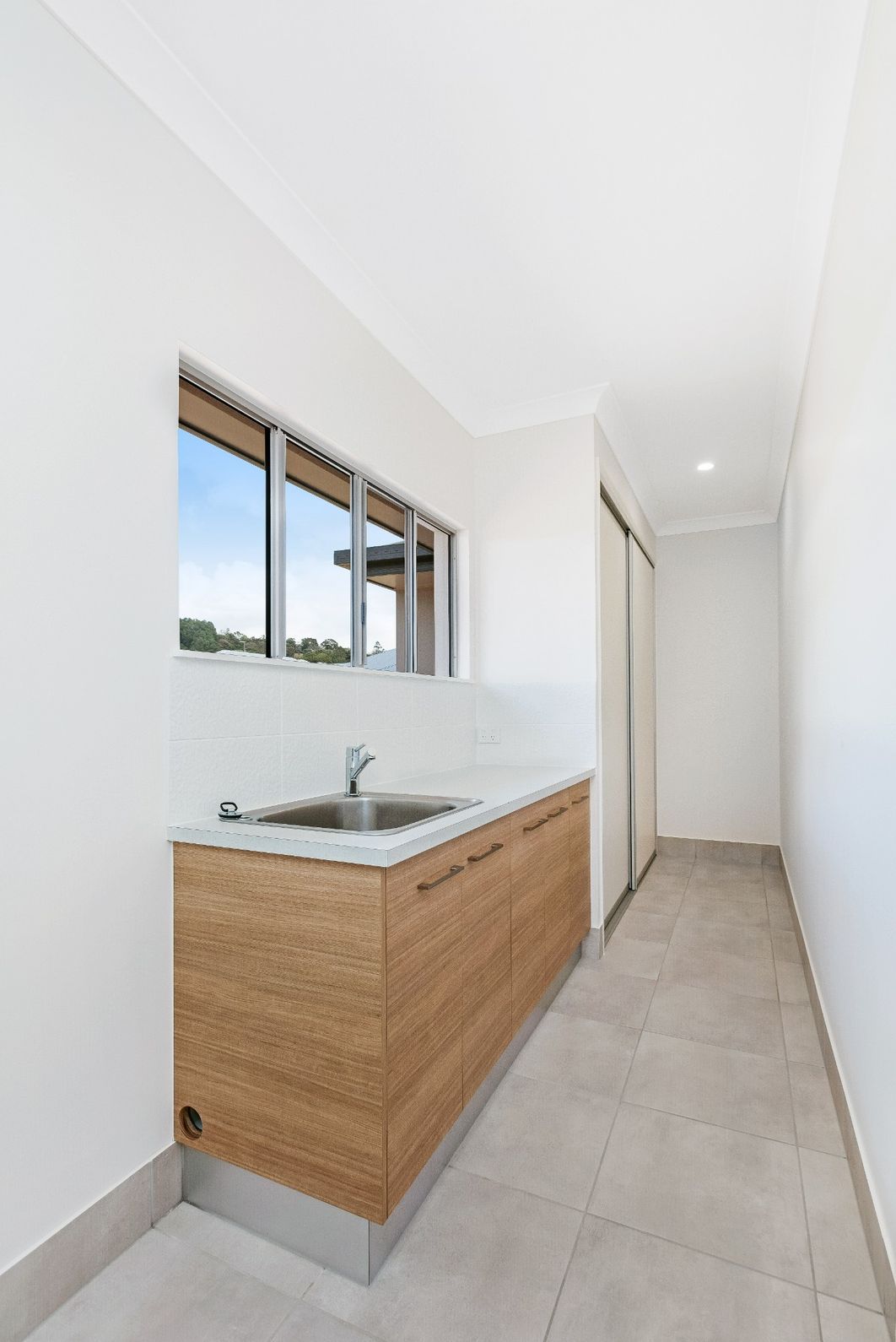 A Kitchen With a Sink, Cabinets and a Window — Ashlee Jones Homes in Gordonvale, QLD