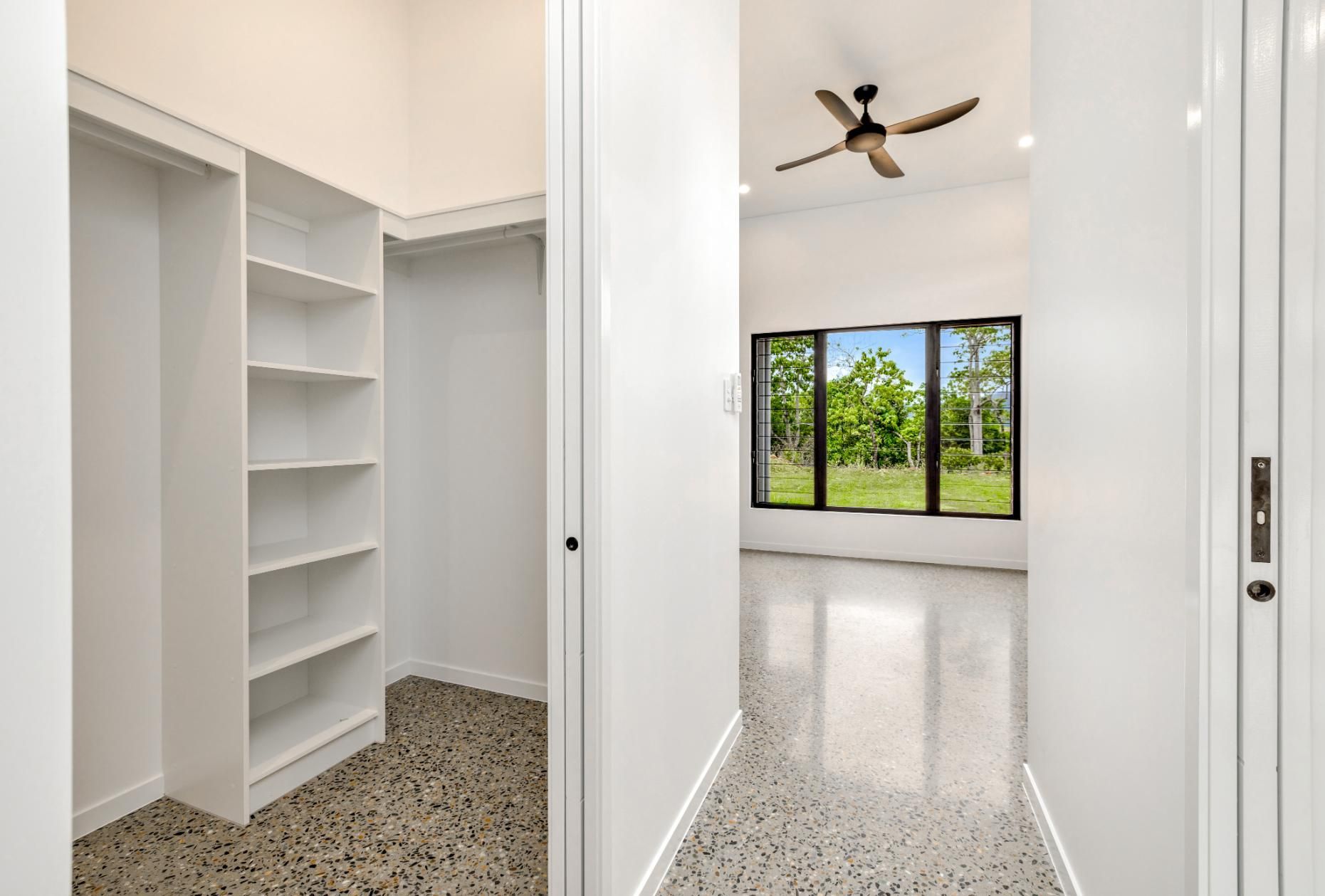 A Walk in Closet in A House with A Ceiling Fan and A Window — Ashlee Jones Homes in Gordonvale, QLD