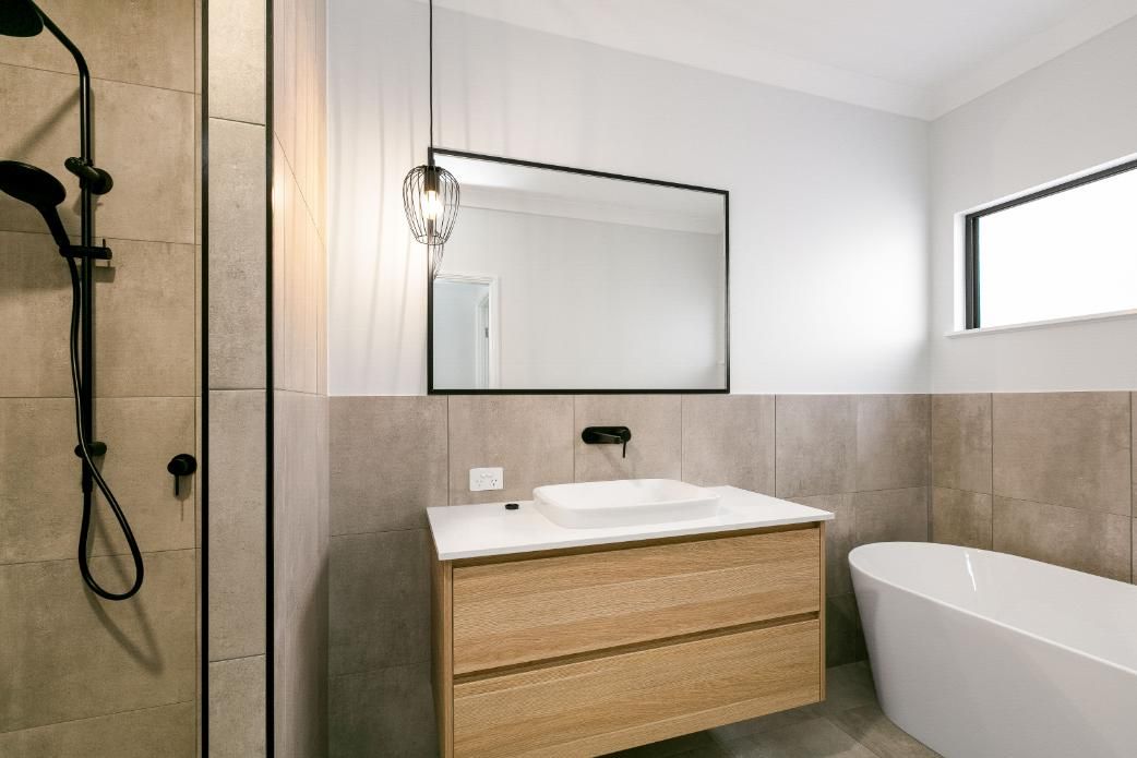 A Bathroom With a Sink, Tub, Shower and Mirror — Ashlee Jones Homes in Gordonvale, QLD