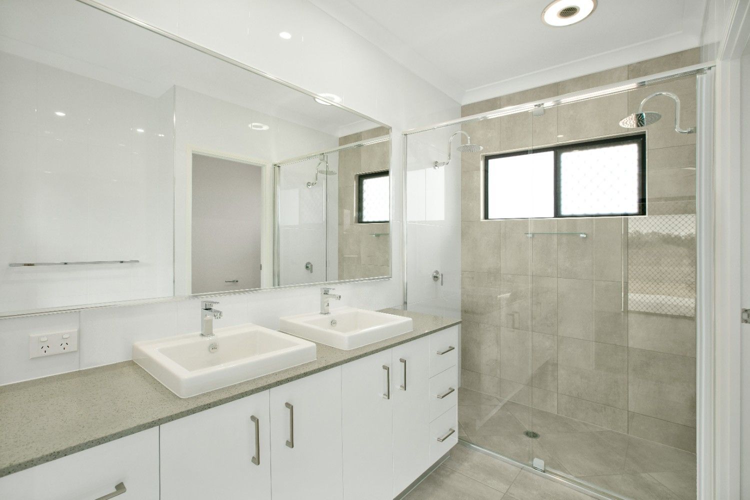A Bathroom With Two Sinks and a Walk in Shower — Ashlee Jones Homes in Gordonvale, QLD