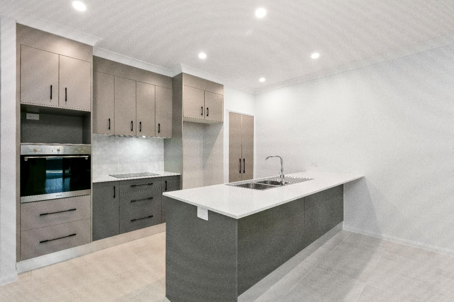 A Kitchen With a Large Island and a Sink — Ashlee Jones Homes in Gordonvale, QLD