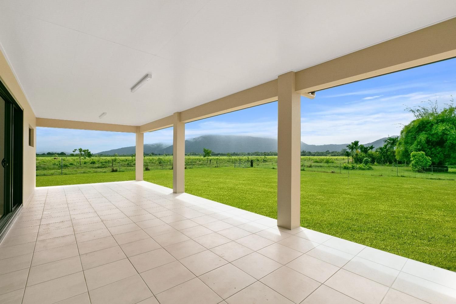 An Empty Patio With a View of a Grassy Field — Ashlee Jones Homes in Gordonvale, QLD