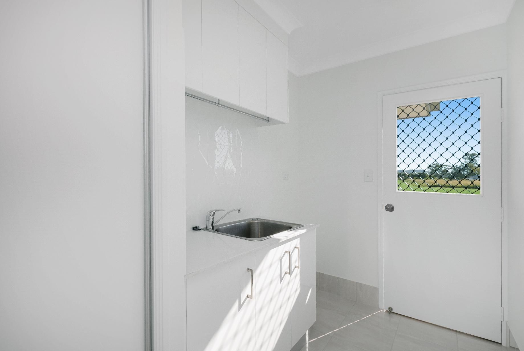 A Kitchen With a Sink, Cabinets, and a Window — Ashlee Jones Homes in Gordonvale, QLD