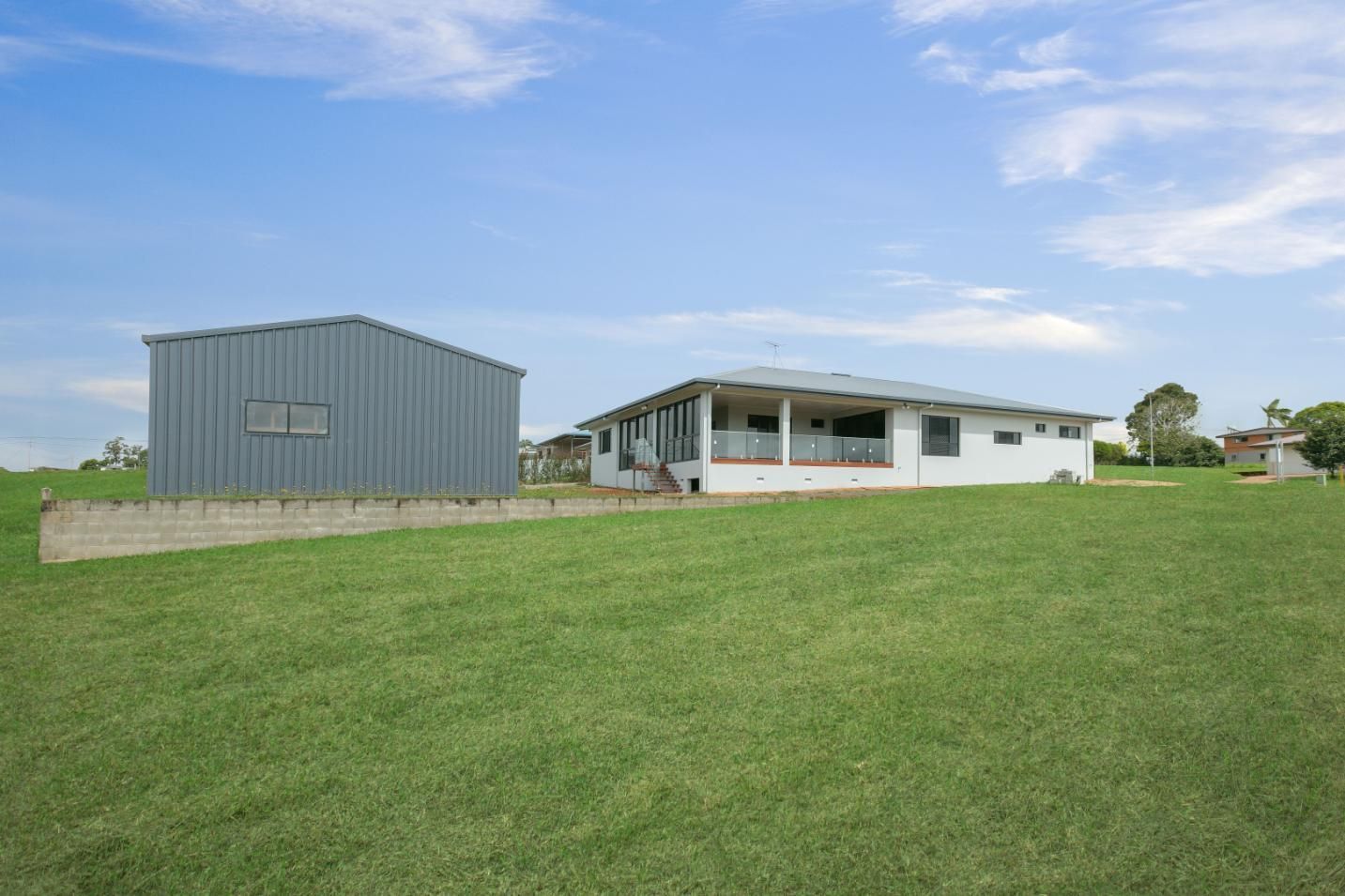 There is a House and a Shed in the Middle of a Grassy Field — Ashlee Jones Homes in Gordonvale, QLD