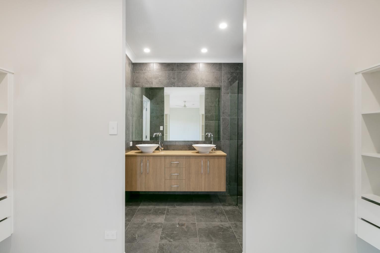 A Bathroom With Two Sinks, a Mirror and a Walk in Shower — Ashlee Jones Homes in Gordonvale, QLD