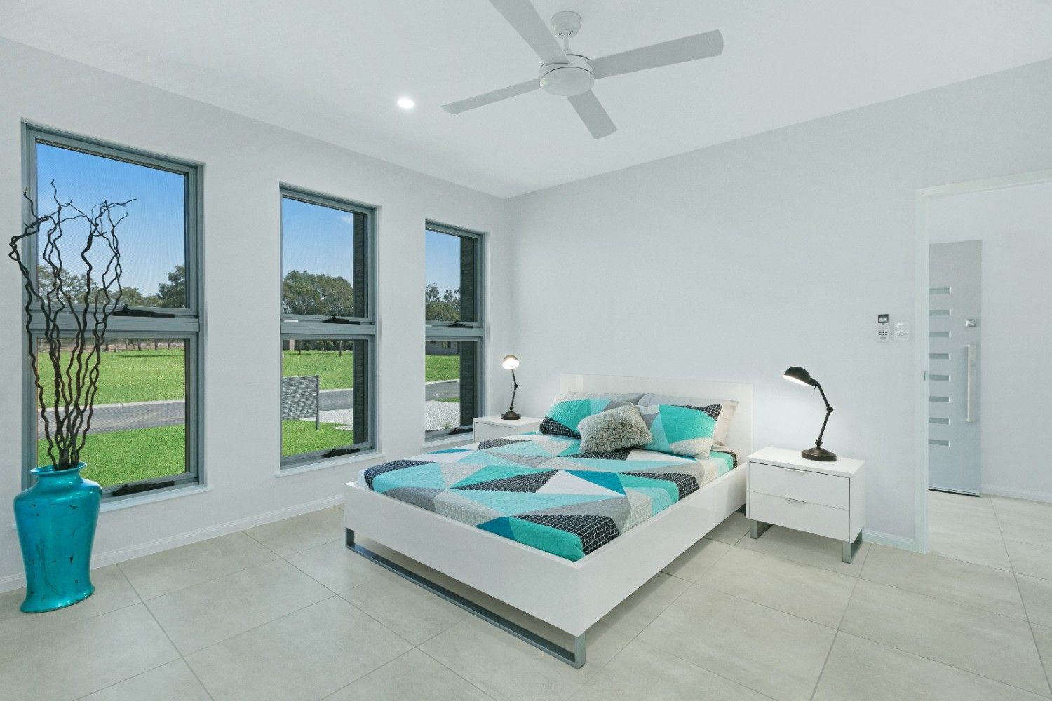 A Bedroom With a Bed and a Ceiling Fan — Ashlee Jones Homes in Gordonvale, QLD
