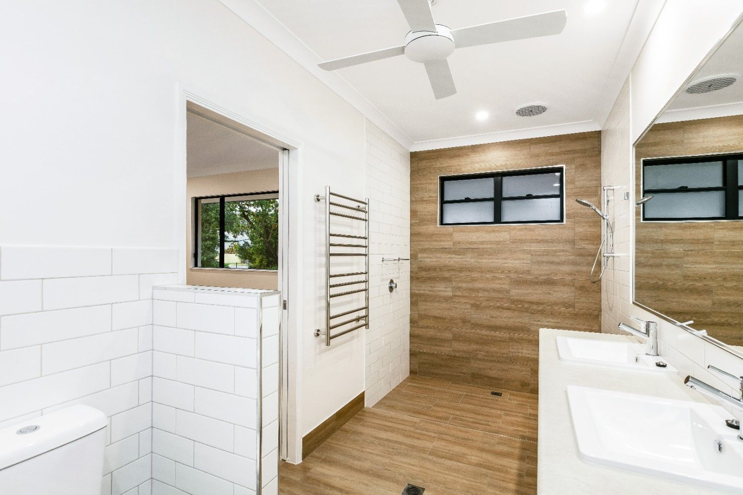 A Bathroom With Two Sinks, a Toilet and a Ceiling Fan — Ashlee Jones Homes in Gordonvale, QLD