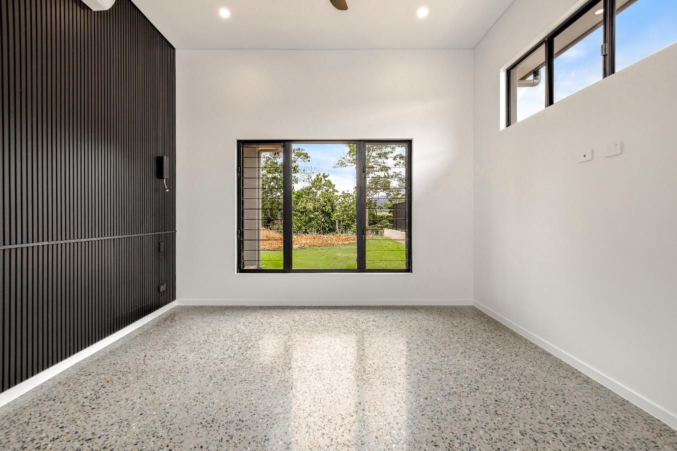 An Empty Room with A Large Window and A Ceiling Fan — Ashlee Jones Homes in Gordonvale, QLD