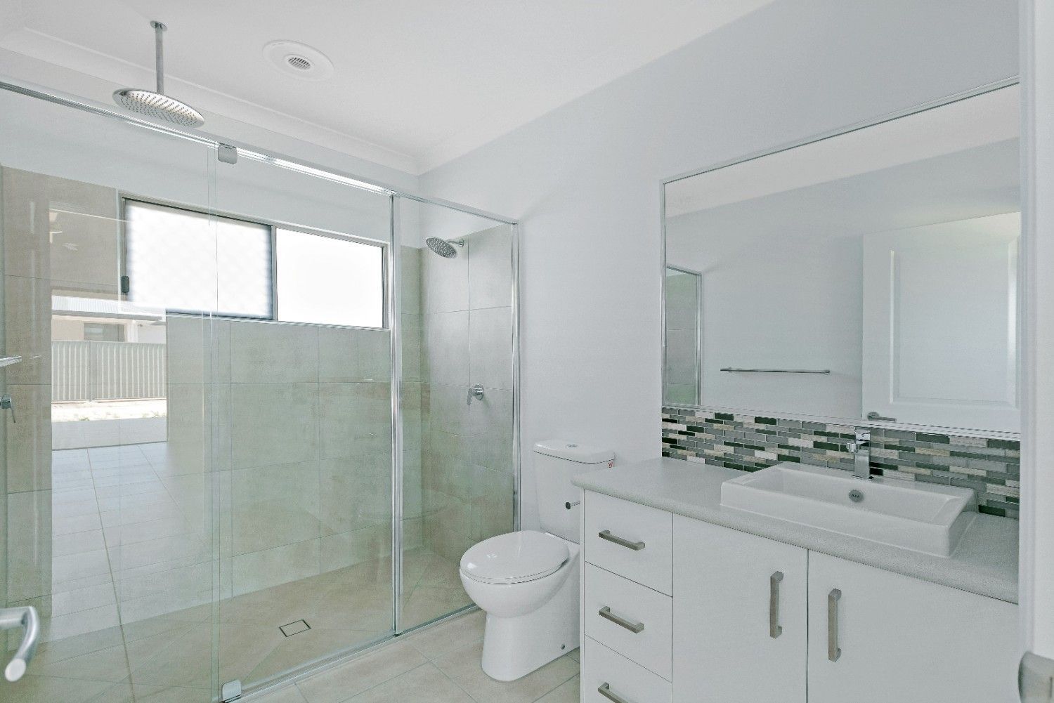 A Bathroom With a Toilet, Sink, and Shower — Ashlee Jones Homes in Gordonvale, QLD