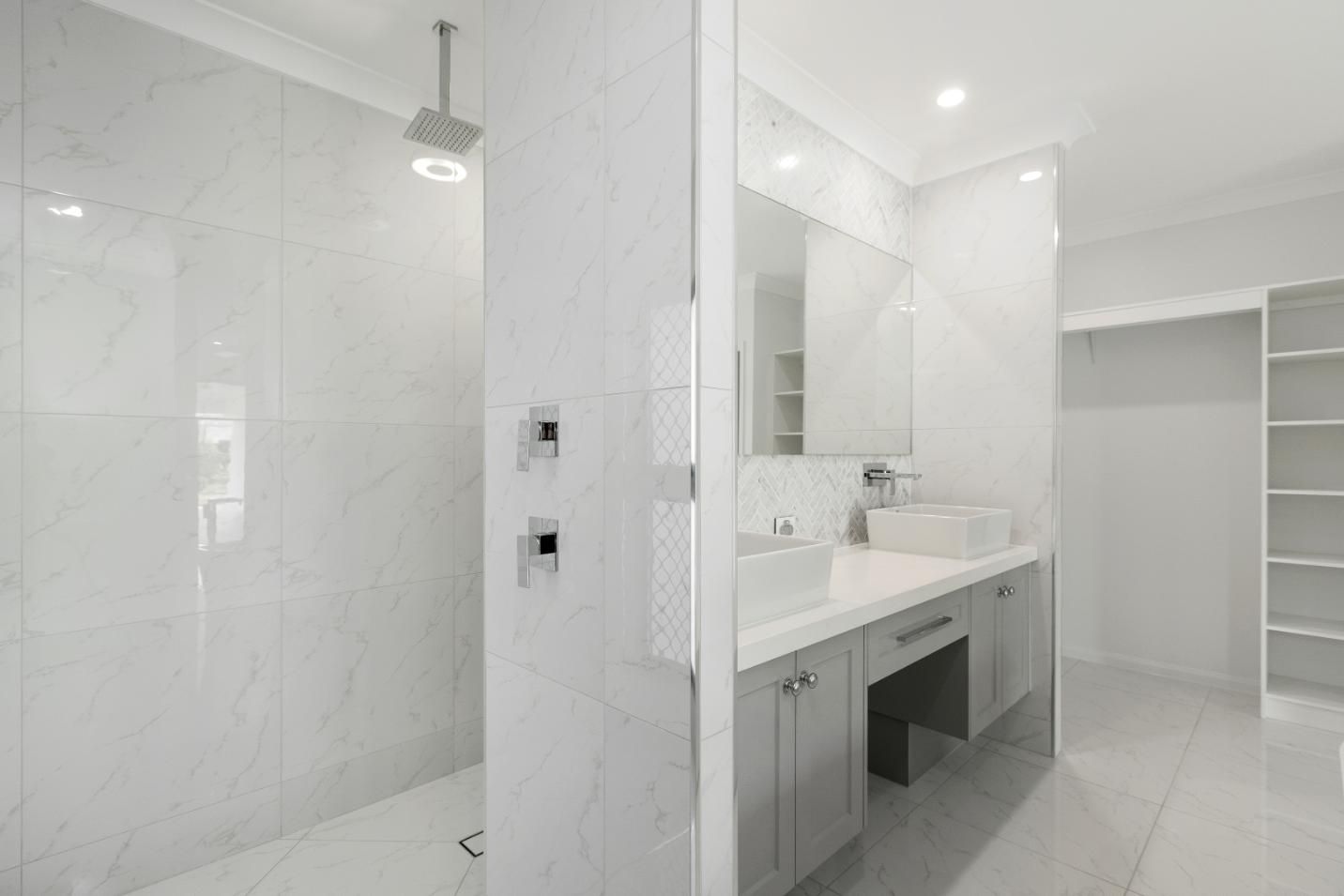 A Bathroom With a Walk in Shower, Sink and Mirror — Ashlee Jones Homes in Gordonvale, QLD