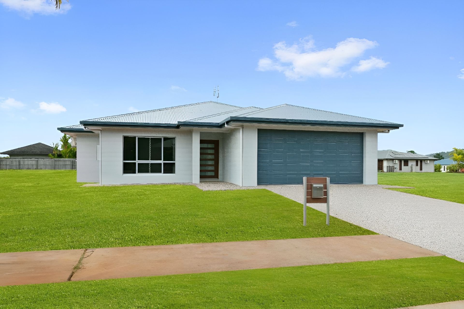 A White House With a Brown Garage Door — Ashlee Jones Homes in Gordonvale, QLD