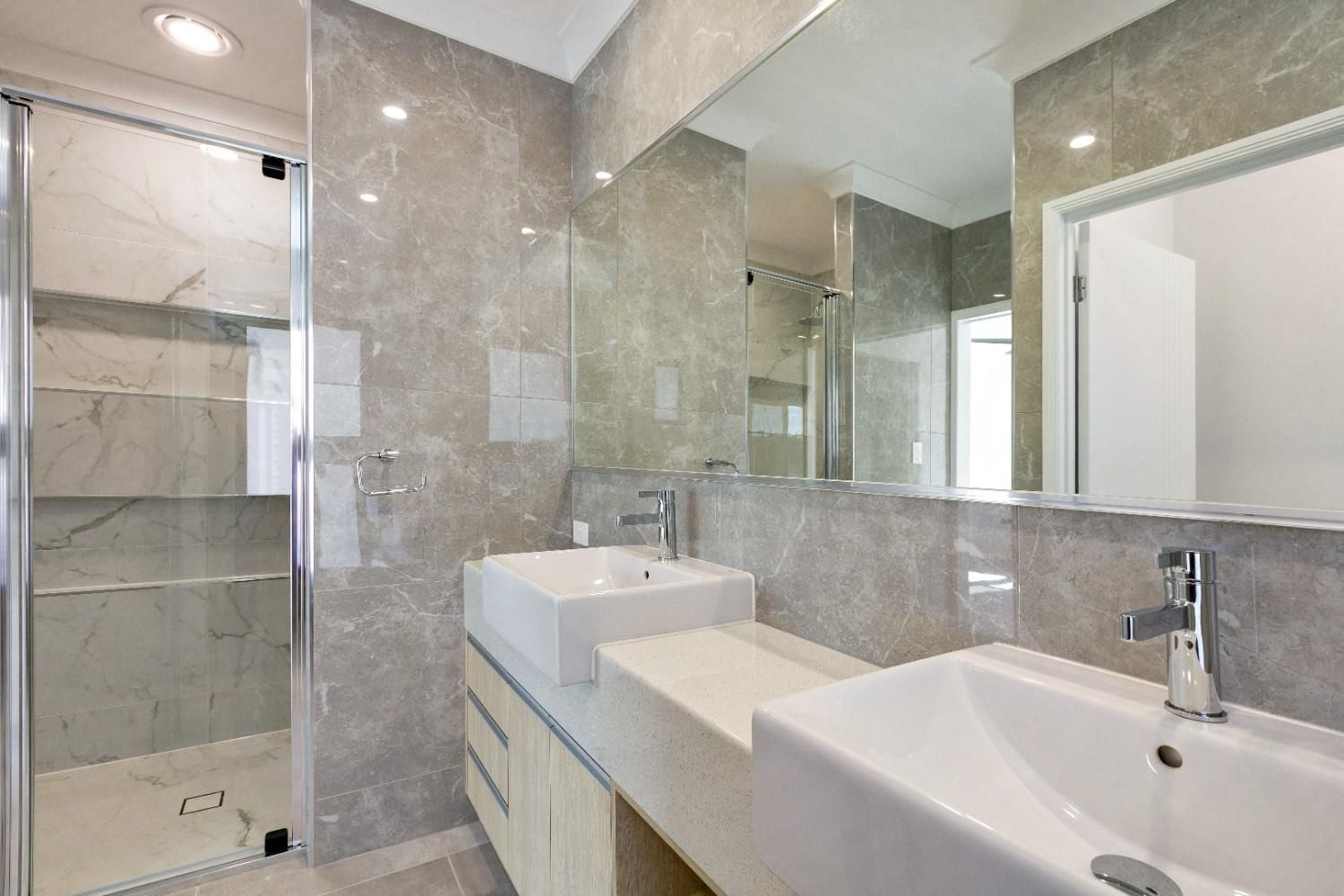 A Bathroom With a Sink, Mirror and Shower — Ashlee Jones Homes in Gordonvale, QLD