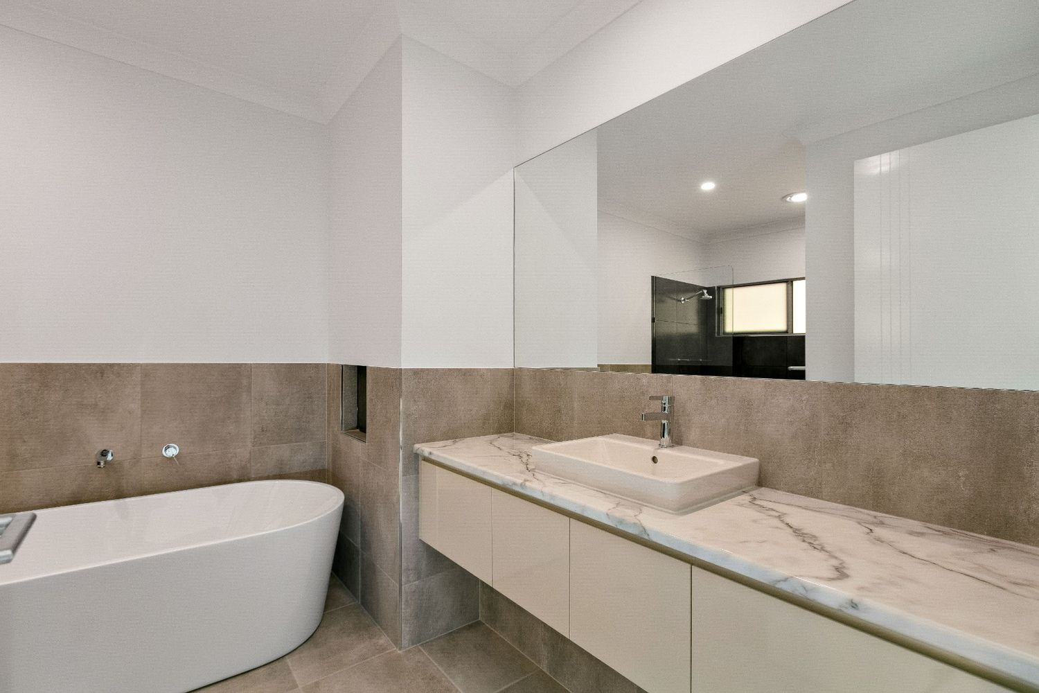 A Bathroom With a Bathtub , Sink and Mirror — Ashlee Jones Homes in Gordonvale, QLD