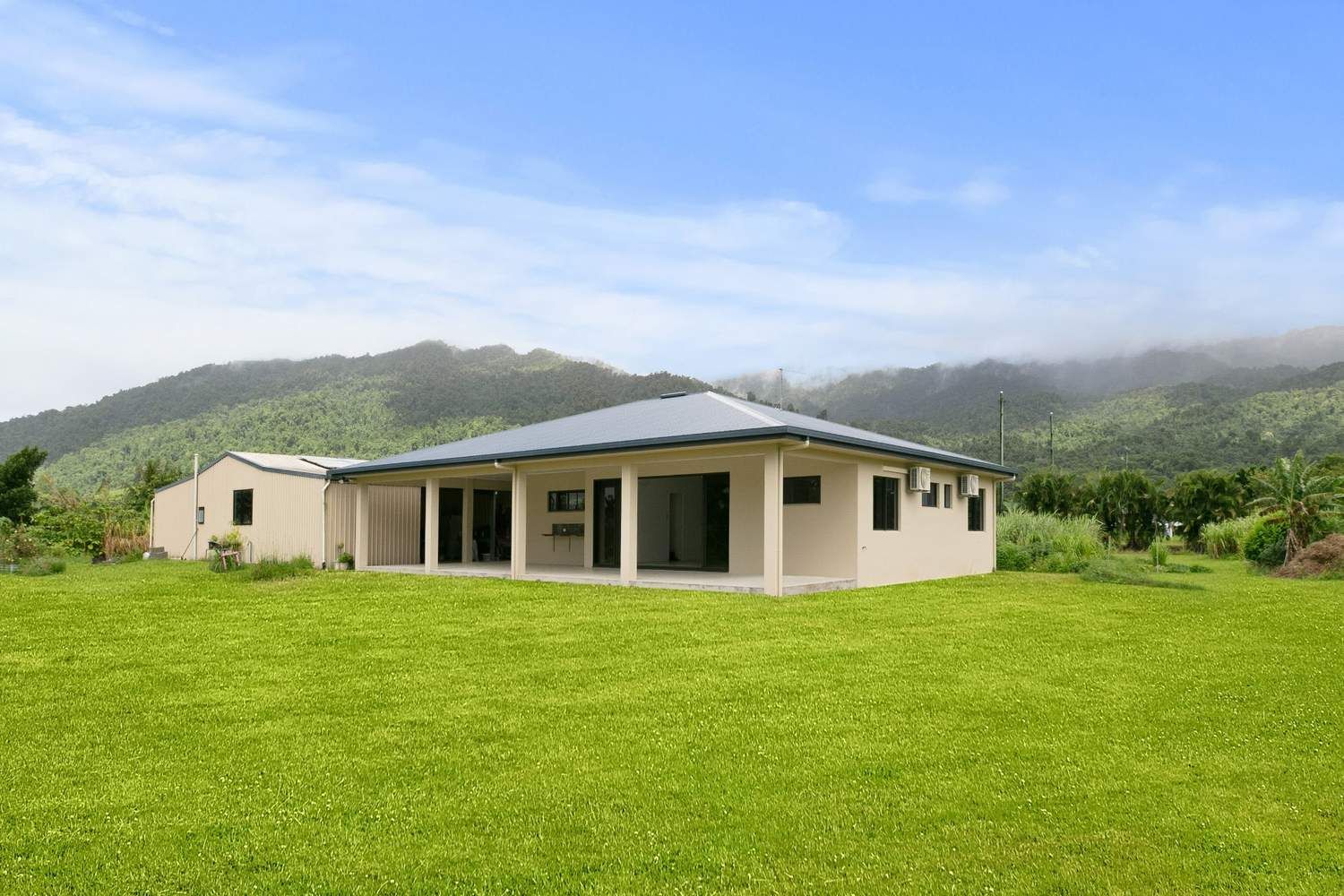 An Empty Room With Sliding Glass Doors and a Ceiling Fan — Ashlee Jones Homes in Gordonvale, QLD
