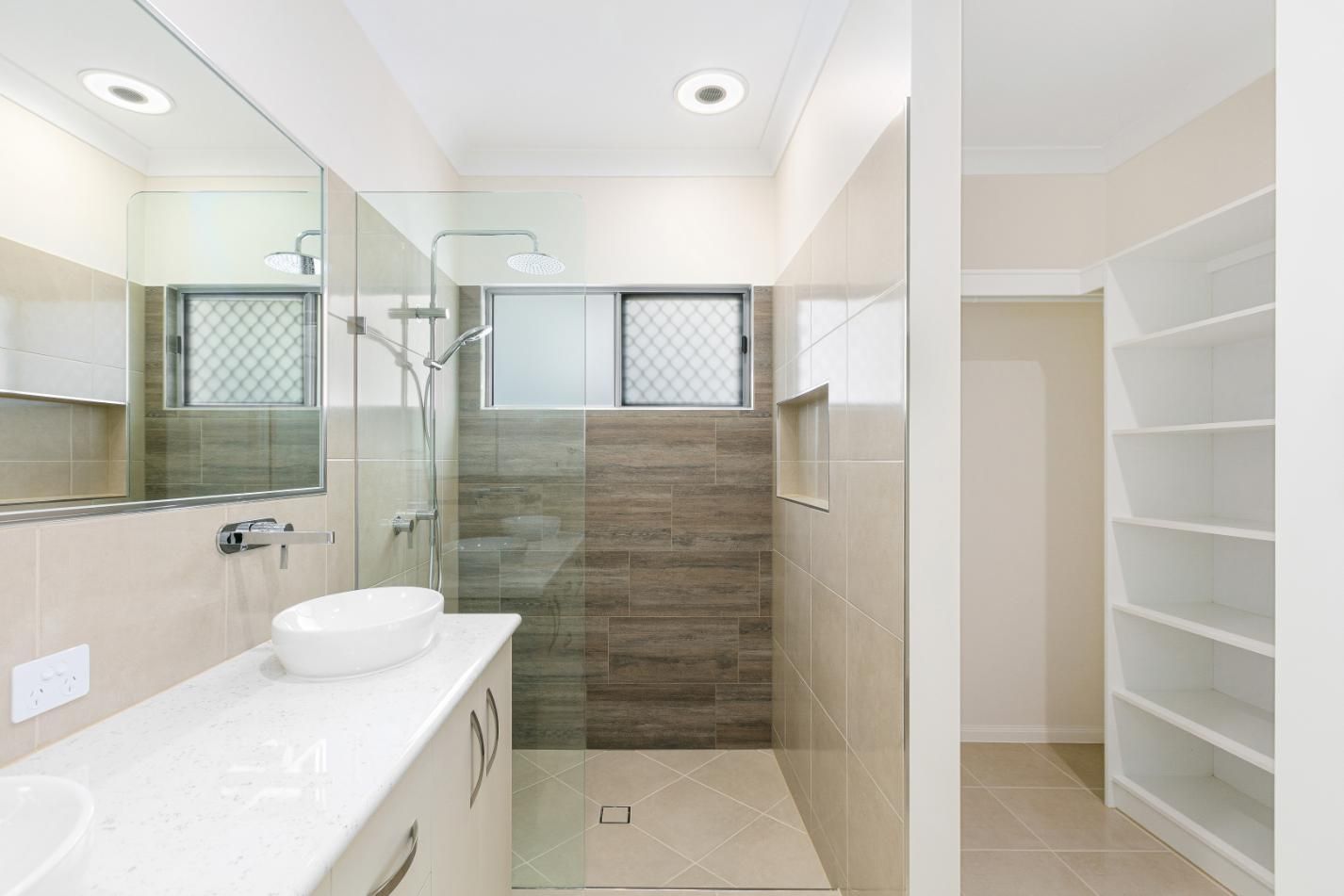 A Bathroom With a Walk in Shower, Sink and Mirror — Ashlee Jones Homes in Gordonvale, QLD