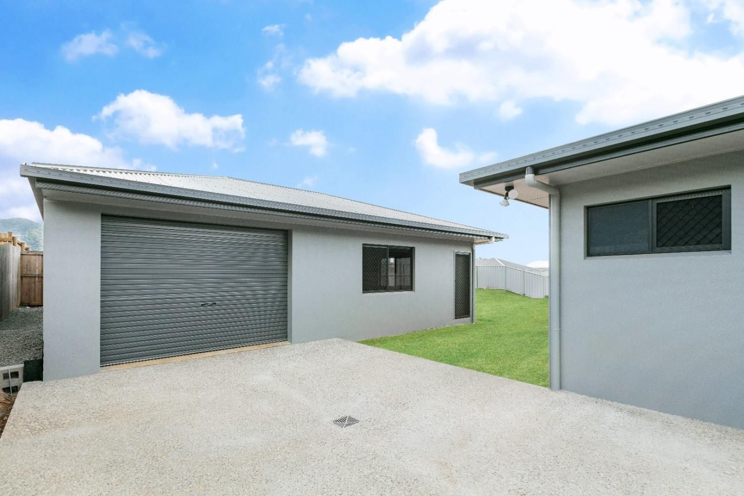 Two Houses Are Sitting Next to Each Other on a Lush Green Lawn — Ashlee Jones Homes in Gordonvale, QLD