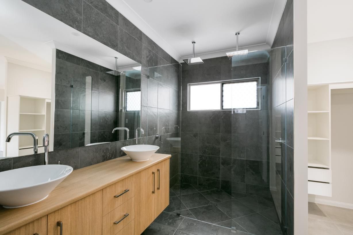 A Bathroom With Two Sinks and a Walk in Shower — Ashlee Jones Homes in Gordonvale, QLD