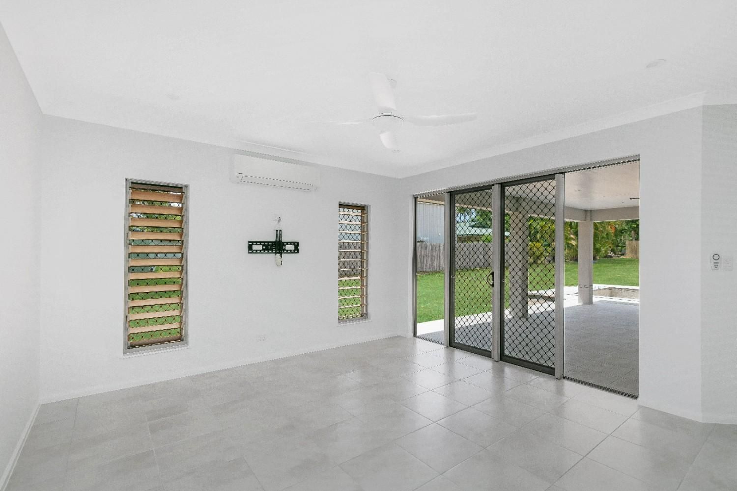 An Open Living Space With a Ceiling Fan and Large Sliding Glass Doors — Ashlee Jones Homes in Gordonvale, QLD